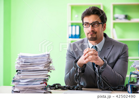 Employee chained to his desk due to workload Employee chained to his desk due to workload 42502490