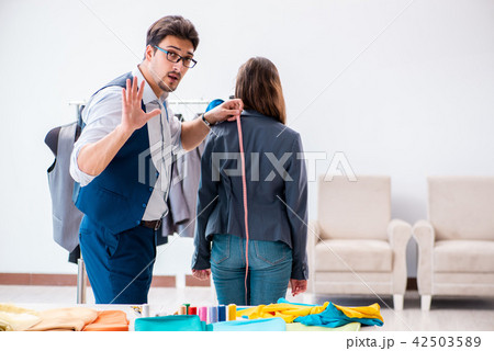 Professional tailor taking measurements for formal suit Professional tailor taking measurements for formal suit 42503589