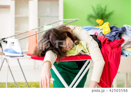 Young woman ironing clothing at home 42503598