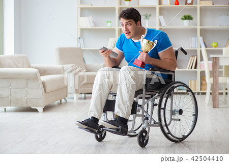 Disabled man watching sports on tv Disabled man watching sports on tv 42504410