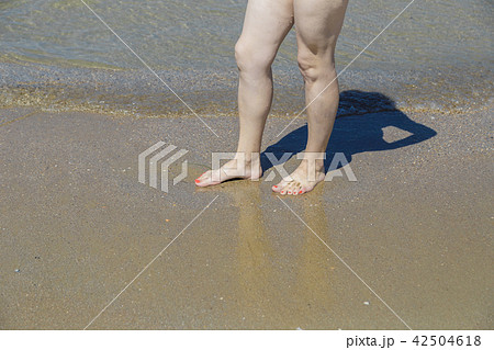 Legs in sea water on the beach on a sunny day. 42504618