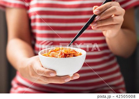 Woman holding chopsticks for eating kimchi cabbage Woman holding chopsticks for eating kimchi cabbage 42505008