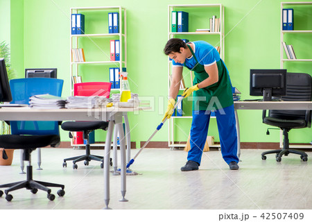 Male handsome professional cleaner doing mopping in the office Male handsome professional cleaner doing mopping in the office 42507409