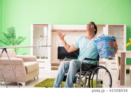 Disabled man on wheelchair doing laundry Disabled man on wheelchair doing laundry 42508056