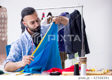 Male tailor working in the workshop on new designs 42508391