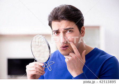 Man panicking because of pimples on the skin Man panicking because of pimples on the skin 42513895