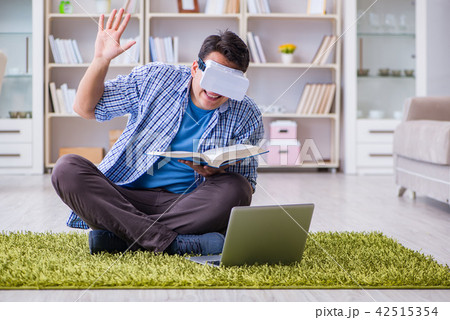 Freelance student with virtual reality glasses at home Freelance student with virtual reality glasses at home 42515354