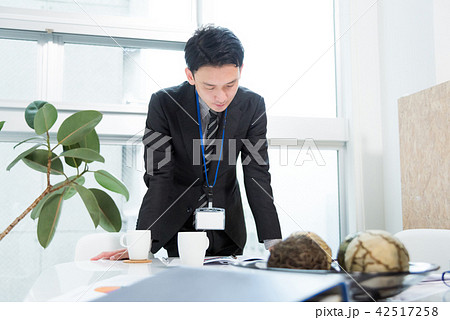机に手を付き考え込むビジネスマンの写真素材