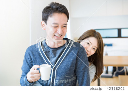 リビングで愛情表現をするカップルの写真素材