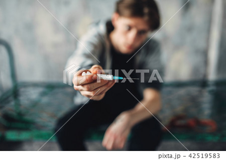 Male junkie reaching out hand with syringe Male junkie reaching out hand with syringe 42519583