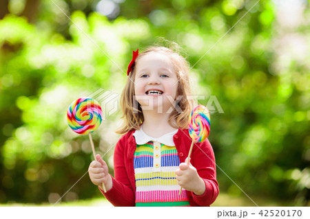 Little girl with colorful candy lollipop 42520170