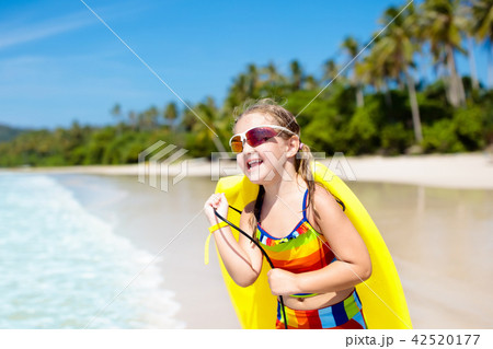 Child surfing on tropical beach. Surfer in ocean. 42520177