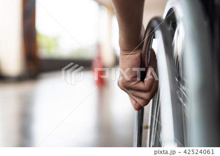 Disabled man hand on wheel of wheelchair Disabled man hand on wheel of wheelchair 42524061