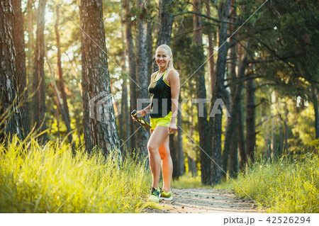 Beautiful blonde athletic woman on a run in the forest Beautiful blonde athletic woman on a run in the forest 42526294