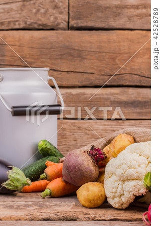 Different vegetables and enamelware milk churn. 42528789
