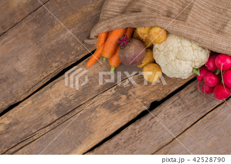 Bag with different vegetables on wood with copyspace. 42528790