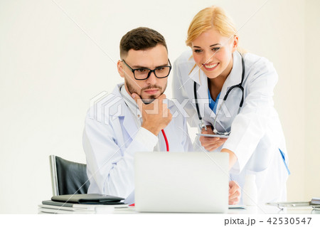 Doctor at hospital works on computer with partner. 42530547