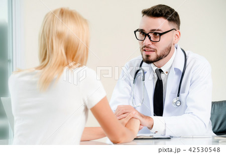 Male Doctor and Female Patient in Hospital Office 42530548