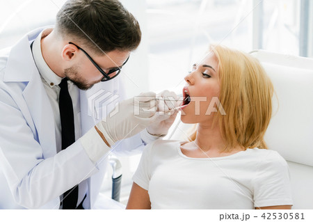 Young dentist examining patient in dental clinic. 42530581