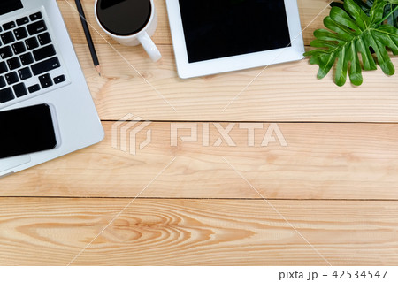 Workspace with laptop, tablet, smartphone on wood. 42534547
