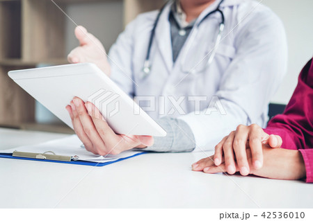 Doctor consulting with patient presenting results Doctor consulting with patient presenting results 42536010