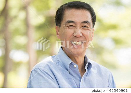 笑顔のミドル男性 公園 木漏れ日の写真素材
