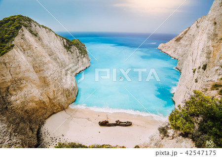 Shipwreck on Navagio beach. Azure turquoise sea water and paradise sandy beach in evening light Shipwreck on Navagio beach. Azure turquoise sea water and paradise sandy beach in evening light 42547175