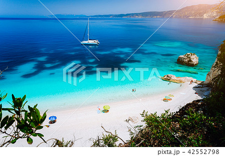 Fteri beach, Cephalonia Kefalonia, Greece. White catamaran yacht in clear blue sea water. Tourists Fteri beach, Cephalonia Kefalonia, Greece. White catamaran yacht in clear blue sea water. Tourists 42552798