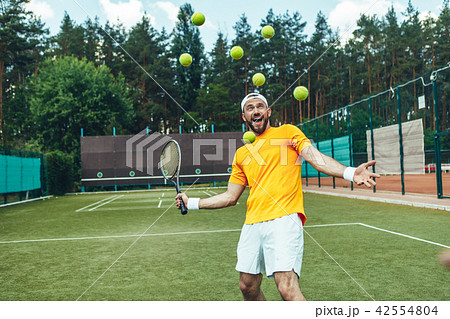 Glad male beating balls with racket Glad male beating balls with racket 42554804