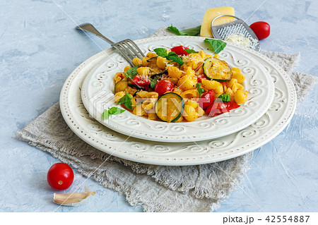 Traditional pasta with tomatoes and zucchini. 42554887