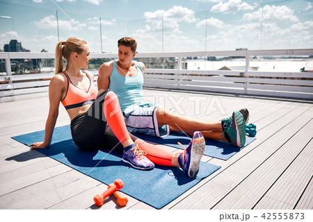 Cheerful lady is talking to guy after workout on roof 42555873