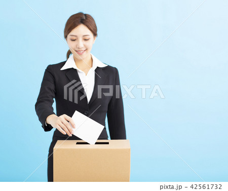 young Woman putting ballot into voting box young Woman putting ballot into voting box 42561732