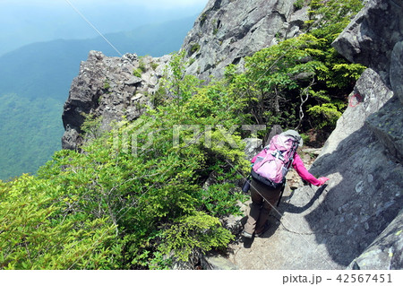 乾徳山の岩場を歩く女性登山者 乾徳山の岩場を歩く女性登山者 42567451