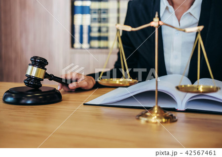 Gavel on wooden table and female Lawyer or Judge working with ag 42567461