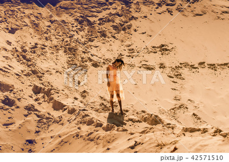 Cute brunette girl in pink dress posing in desert 42571510