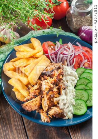 Greek gyros dish with french fries and vegetables Greek gyros dish with french fries and vegetables 42572811