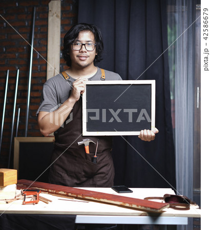 Asian Carpenter Working in Woodworking Workshop 42586679
