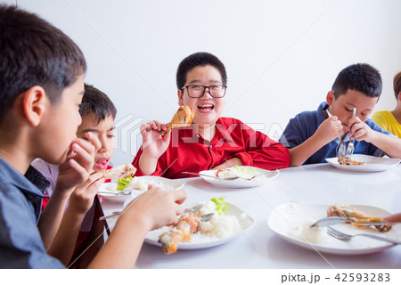 boy smiling while having lunch with friends boy smiling while having lunch with friends 42593283