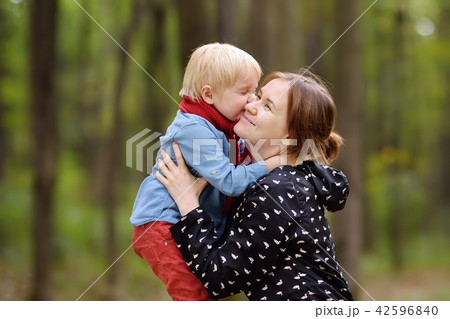 Little boy with his young mother enjoy stroll in the forest Little boy with his young mother enjoy stroll in the forest 42596840
