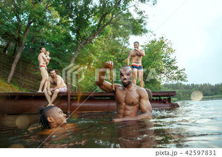 Enjoying river party with friends. Group of beautiful happy young people at the river together 42597831