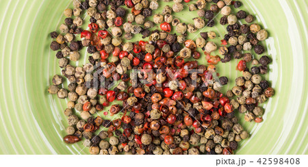 Mix of peppercorns in a green dish Mix of peppercorns in a green dish 42598408