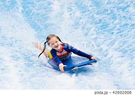 Little girl surfing in beach wave simulator 42602006