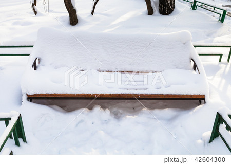 snow-covered bench at urban square in winter snow-covered bench at urban square in winter 42604300