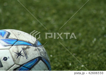 人工芝に転がるサッカーボールの写真素材