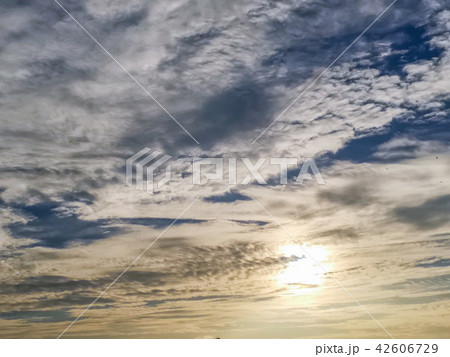 Sun behind clouds with blue sky 42606729