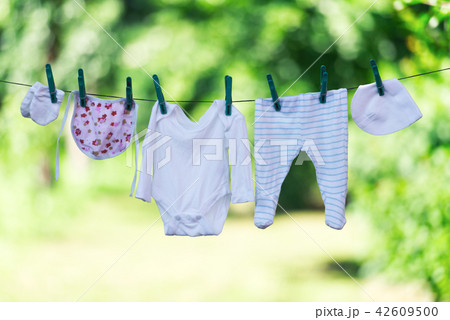 Baby clothes on clothesline in garden 42609500
