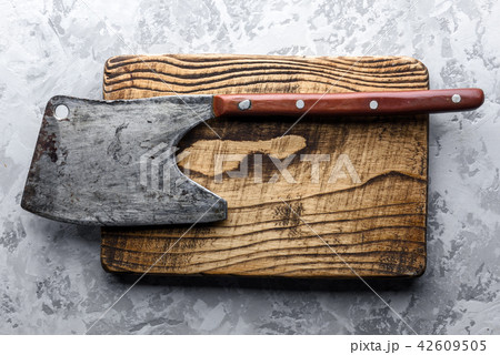 Old rustic axe for meat on a wooden board Old rustic axe for meat on a wooden board 42609505