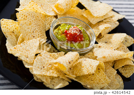 Nachos chips with sauces on black plate Nachos chips with sauces on black plate 42614542