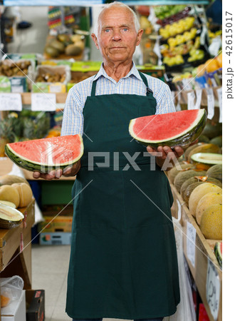 Seller proffering fruits and vegetables 42615017