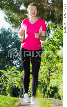 Sporty girl in pink T-shirt is running around 42615774